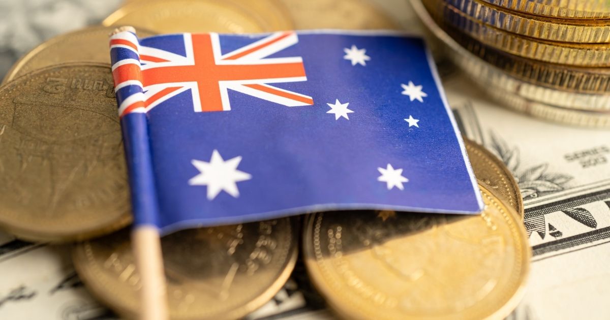 Australian flag with gold coins representing the intersection of government monetary policy and precious metals as an inflation hedge